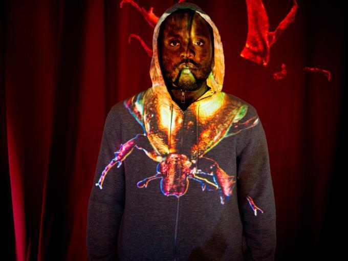 un homme noir eclairé par une projection lunimeuse