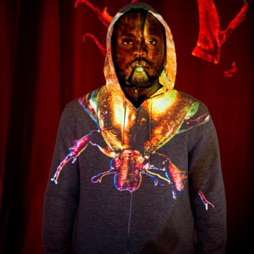 un homme noir eclairé par une projection lunimeuse