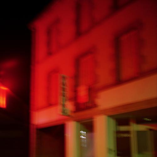 immeuble de nuit eclaire en rouge dans une ambiance de polar